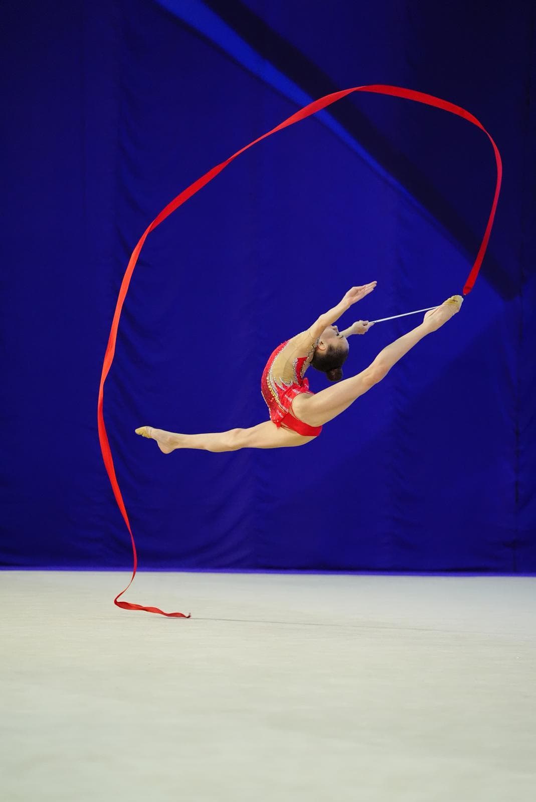 Gymnast performing a split leap with ribbon
